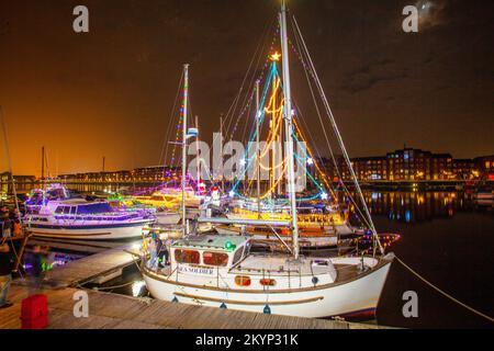 Lumières de Noël en mer. Une brillante parade de bateaux de vacances à Preston, Lancashire décembre 2022. Yachts amarrés et voiliers décorés de lumières de Noël étincelantes à Preston Marina. Une soirée de Noël s'allume pour les foules qui bordent le mur du quai tandis que les porte-couchettes illuminent leurs bateaux et profitent d'une voile en soirée sous les lumières festives. Banque D'Images