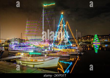 Lumières de Noël en mer. Une brillante parade de bateaux de vacances à Preston, Lancashire décembre 2022. Yachts amarrés et voiliers décorés de lumières de Noël étincelantes à Preston Marina. Une soirée de Noël s'allume pour les foules qui bordent le mur du quai tandis que les porte-couchettes illuminent leurs bateaux et profitent d'une voile en soirée sous les lumières festives. Banque D'Images