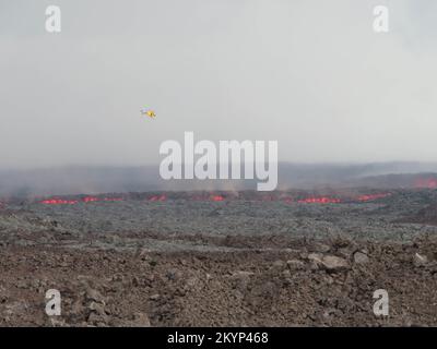 Mauna Loa, Hawaï, États-Unis. 30th novembre 2022. Une équipe sur le terrain a documenté l'emplacement de l'avant de l'écoulement le plus près du chemin Saddle le 30 novembre 2022, entre 3 h 00 et 4 h 00 de la TVH. Cette photo montre l'avant de l'écoulement de lave, avec un hélicoptère pour la balance. La photo a été prise en regardant vers le sud depuis la route Hilo-Kona, à environ 4 miles au sud de Saddle Road et à un mile à l'ouest de la route de l'observatoire Mauna Loa. Au moment où la photo a été prise, le débit était à environ 500 m au sud de la route Hilo Kona; le débit a traversé la route Hilo Kona pendant la nuit. (Credit image: © USGS/ZUMA Press Wire se Banque D'Images