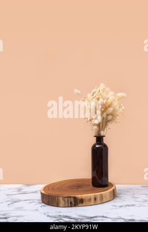 Bouquet sec d'épillets en bouteille de verre foncé sur table en marbre avec fond clair. Résumé scène minimale avec podiums. Modèle de maquette pour le produit. Photo de haute qualité Banque D'Images