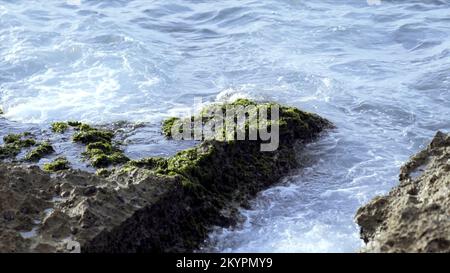 De petites vagues frappent et éclabousse le rivage de la mer.Action.Vagues qui frappent le rock.Éclaboussures de vagues sur de petites roches. Banque D'Images