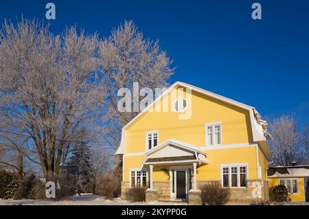 Jaune avec bordure blanche maison de style grange de deux étages en hiver. Banque D'Images