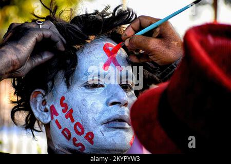 Kolkata, Inde. 01st décembre 2022. Un artiste a vu le visage peindre un démonstrateur pendant la campagne de sensibilisation de la Journée mondiale du sida. La Journée mondiale du sida est célébrée chaque année sur 1 décembre pour sensibiliser et soutenir les personnes vivant avec le VIH/sida. Crédit : SOPA Images Limited/Alamy Live News Banque D'Images