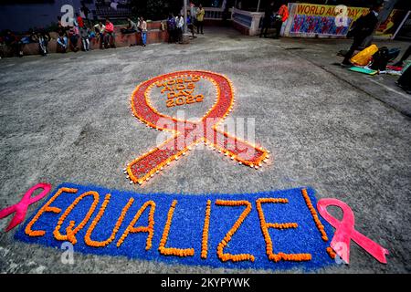 Kolkata, Inde. 01st décembre 2022. Un ruban rouge avec les bougies allumées vues pendant la campagne de sensibilisation à la Journée mondiale du sida. La Journée mondiale du sida est célébrée chaque année sur 1 décembre pour sensibiliser et soutenir les personnes vivant avec le VIH/sida. Crédit : SOPA Images Limited/Alamy Live News Banque D'Images