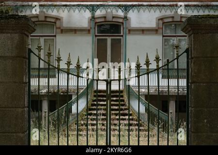 Vue à travers les portes d'un domaine de campagne abandonné au Portugal Banque D'Images