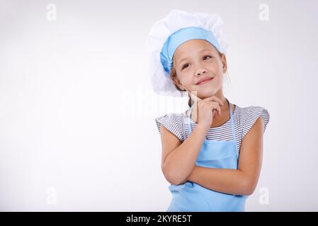 Je suis un boulanger heureux.Une petite fille mignonne vêtue de vêtements de cuisine. Banque D'Images