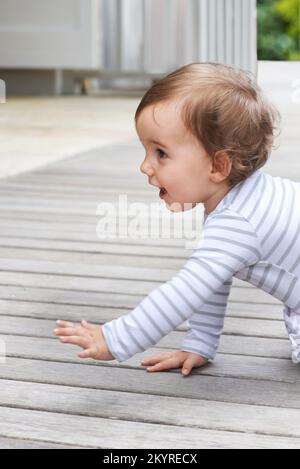 Shes un speedster. un joli petit bébé rampant sur une terrasse. Banque D'Images