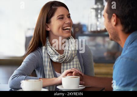 La faire rire. Un jeune couple aimant dans un café ensemble. Banque D'Images