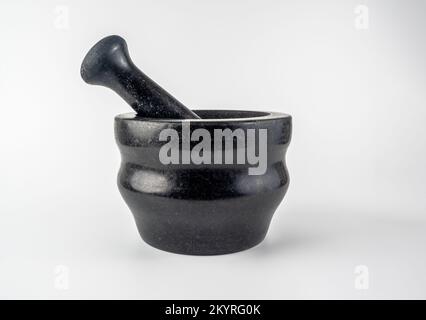mortier traditionnel de granit noir et pristle isolés sur un fond blanc Banque D'Images