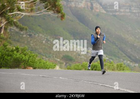 Profitez d'un jogging dans l'air frais de l'hiver. Un jeune homme qui court à l'extérieur. Banque D'Images