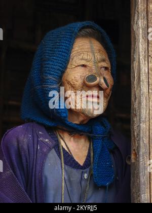 Ziro, Arunachal Pradesh, Inde - 02 24 2009 : Portrait de la vieille femme tribale d'Apatani avec tatouage facial traditionnel et prises de nez portant une écharpe bleue Banque D'Images