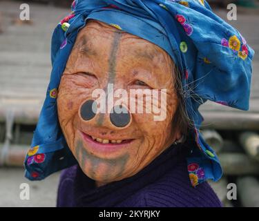 Ziro, Arunachal Pradesh, Inde - 03 04 2014 : Portrait en gros plan de la vieille femme tribale d'Apatani souriante avec des tatouages faciaux traditionnels et des prises de nez Banque D'Images