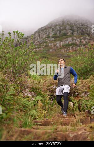 C'est tout en bas de la colline d'ici. Un jeune homme qui descend une colline en plein air. Banque D'Images