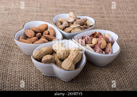 Arachides et amandes dans des assiettes en forme de coeur sur toile Banque D'Images