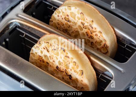 Des crumettes grillées cuites dans un grille-pain électrique. Sur fond de pierre sombre Banque D'Images