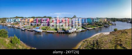 Façade de maisons colorées le long de la baie dans la communauté pittoresque de Navarre en Floride. Vue panoramique d'un quartier en bord de mer avec de petits bateaux amarrés en fr Banque D'Images