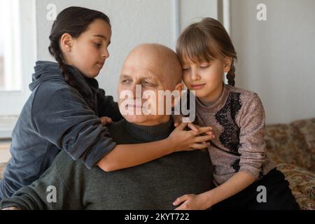 Grand-père ukrainien et deux petites-filles embrassant Banque D'Images