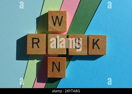 Win et Risk, mots en lettres de l'alphabet en bois en forme de mots croisés isolés sur l'arrière-plan Banque D'Images