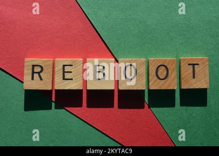 Redémarrer, mot en lettres de l'alphabet en bois isolées sur fond rouge et vert Banque D'Images