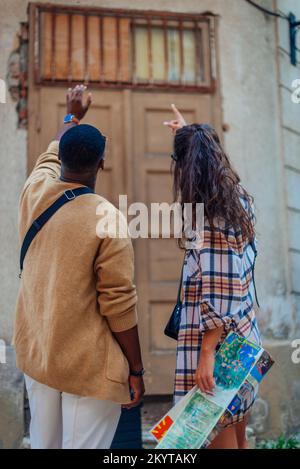 Une femme essaie d'expliquer quelque chose à son petit ami. Ils pointent dans la même direction Banque D'Images