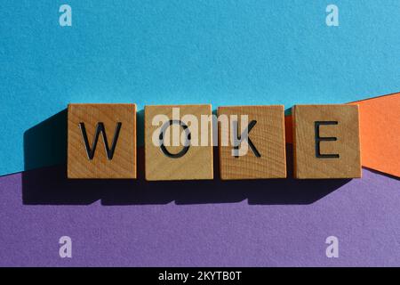 Woke, mot signifiant être alerte à l'injustice dans la société dans des lettres de l'alphabet de bois isolées sur le fond Banque D'Images