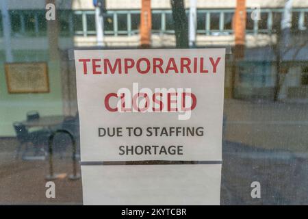 San Antonio, Texas- attention sélective d'une signalisation avec temporairement fermé en raison de pénurie de personnel.signalisation affichée sur une fenêtre en verre avec réflexion de Banque D'Images