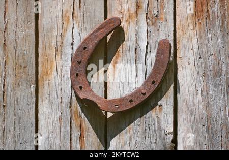 Vieux fer à cheval rouillé sur un mur en bois. Symbole de chance. Banque D'Images