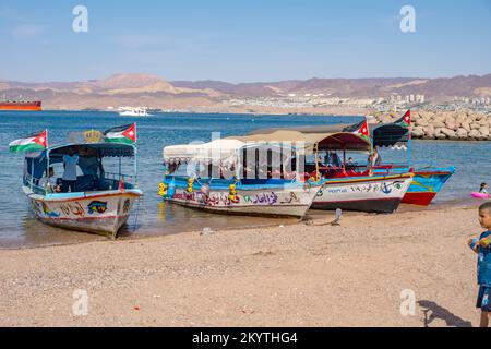 Des bateaux se sont arrêtés sur la plage d'Al-Ghandour à Aqaba en Jordanie, en regardant vers les collines d'Isreal et d'Égypte Banque D'Images