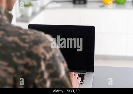 Surveillance et contrôle du concept d'information opposé, Soldier en uniforme de camouflage travaillant sur ordinateur portable pour opération d'information Banque D'Images