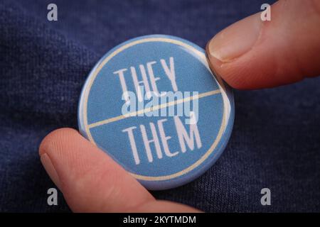 Une personne qui leur montre leur pronoms en portant un badge. Banque D'Images
