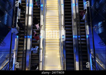 Dubaï, Émirats arabes Unis - les navetteurs parcourent une banque d'escaliers mécaniques à l'intérieur de la station de métro de Dubaï. Design intérieur futuriste de l'arrêt BurJuman. Horizontale. Banque D'Images