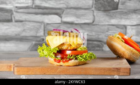 Hamburger de poulet frais et savoureux sur une table en bois. Le hamburger s'est cassé et est tombé Banque D'Images