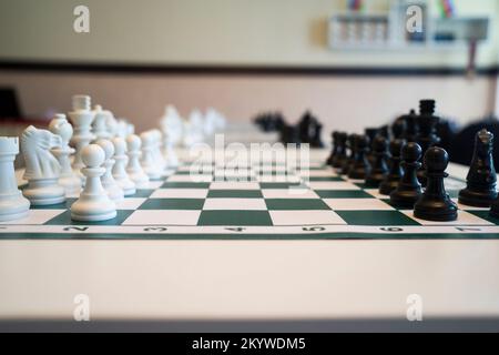 échiquier avec pièces noires et blanches sur la table. Banque D'Images