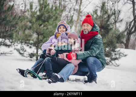 Photo de l'excitée mari doux femme petit enfant porte coupe-vent s'amuser ensemble en profitant du temps neigeux à l'extérieur du parc urbain Banque D'Images