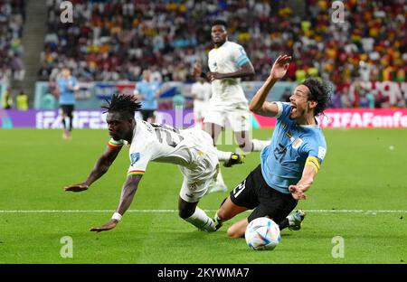 L'Uruguay Edinson Cavani est retiré par Seidu Alidu au Ghana, qui n'est pas puni lors du match H de la coupe du monde de la FIFA au stade Al Janoub d'Al-Wakrah, au Qatar. Date de la photo: Vendredi 2 décembre 2022. Banque D'Images