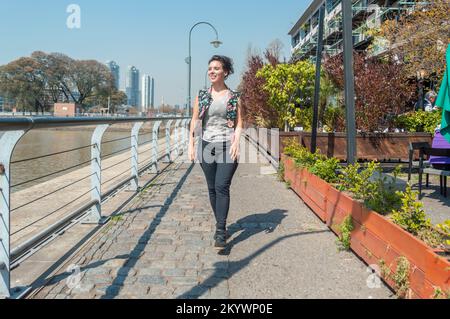 Vue de face femme adulte caucasienne, sourire va heureux de marcher dans la rue, à Puerto Madero Buenos Aires, argentine. Banque D'Images