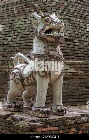 Céramique gardien de lion traditionnel et protecteur à la base de l'ancienne stupa de brique de l'ancien temple bouddhiste Wat Lok Moli ou Lok Molee, Chiang Mai, Thaïlande Banque D'Images