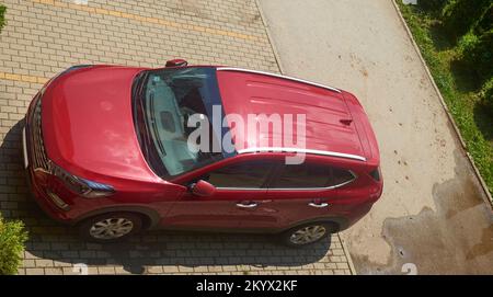 Voiture rouge sur une place de parking - top-shot Banque D'Images