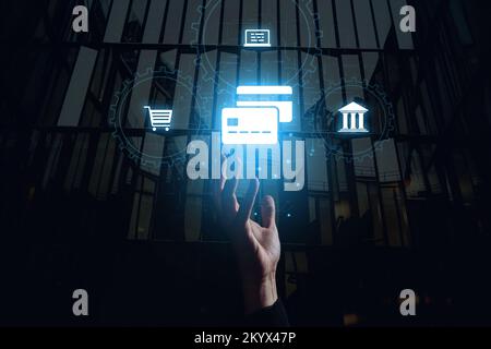 Le concept de payer pour des services avec une carte bancaire en ligne. La main atteint pour l'hologramme. Banque D'Images