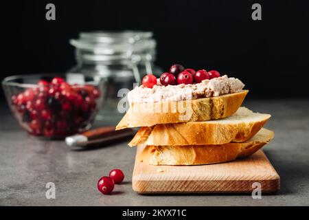 Foie de poule aux oies, canneberges sur fond sombre. Banque D'Images