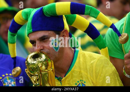 Lusail, Qatar. 02nd décembre 2022. Football, coupe du monde 2022 au Qatar, Cameroun - Brésil, tour préliminaire, Groupe G, jour du match 3, Au stade Lusail à Lusail, un fan du Brésil embrasse une réplique du trophée de la coupe du monde avant le match. Crédit : Tom Weller/dpa/Alay Live News Banque D'Images