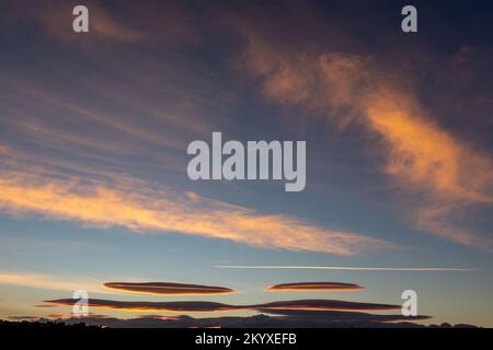 Nuages lenticulaires et nuages cirrus dans le ciel avec la lune à l'aube Banque D'Images