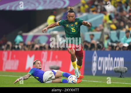 Au Cameroun, Pierre Kunde passe devant l'Antony brésilien lors du match G de la coupe du monde de la FIFA au stade Lusail à Lusail, au Qatar. Date de la photo: Vendredi 2 décembre 2022. Banque D'Images