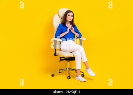 Photo de corps complet de jeune esprit boss femme d'affaires porter chemise bleue fauteuil regardant espace vide nouvelle idée isolée sur fond jaune couleur Banque D'Images