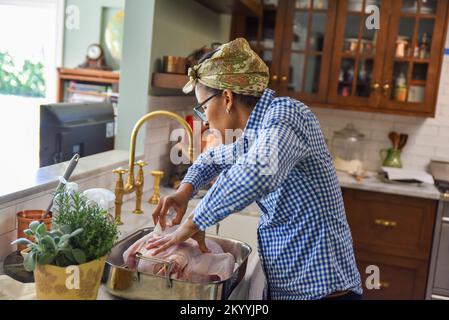 Afrique femme américaine préparant une grande dinde crue pour un dîner de Thanksgiving en famille Banque D'Images