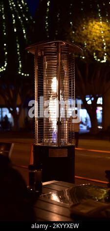 Grande table chauffante extérieure au propane en acier inoxydable, assise au-dessus d'une table de restaurant Banque D'Images