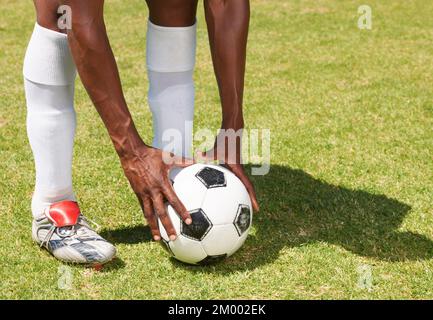 Placer son coup de pied libre. Image rognée d'un homme plaçant un ballon de football pour un coup de pied libre pendant un match. Banque D'Images
