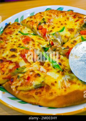 Des pizzas de style américain fermer uo macro avec roue de coupe Banque D'Images