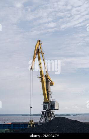 Lever la grue de tour au-dessus du terminal côtier pendant que le charbon de bois est chargé sur les trains pour le transport Banque D'Images