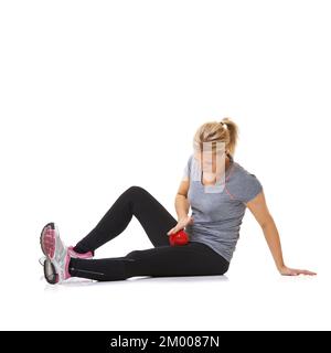 Serrer ses cuisses intérieures. Une jeune femme utilisant une balle d'exercice pour s'entraîner. Banque D'Images